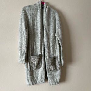 Adorable women’s cardigan with faux fur pocket detail.